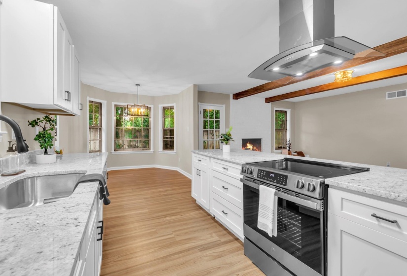 Contemporary kitchen featuring white cabinetry, light-toned countertops, and wood-finish flooring