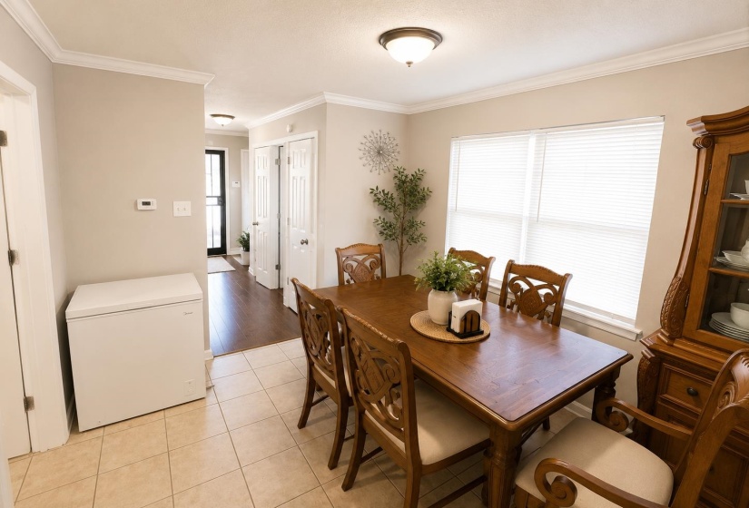 Dining area featuring neutral wall tones, crown molding, and a flush-mount ceiling light fixture