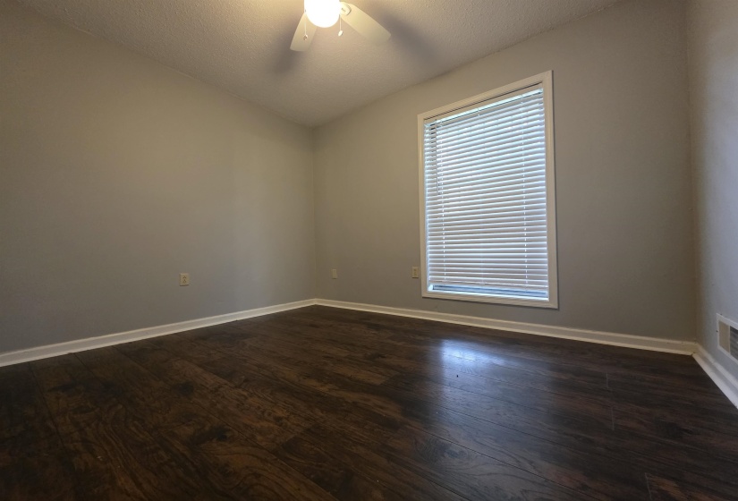 Room featuring dark wood-finish flooring, light gray walls, and white baseboards