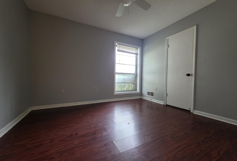 Room featuring wood-finish flooring, a window with blinds, a ceiling fan, and painted walls