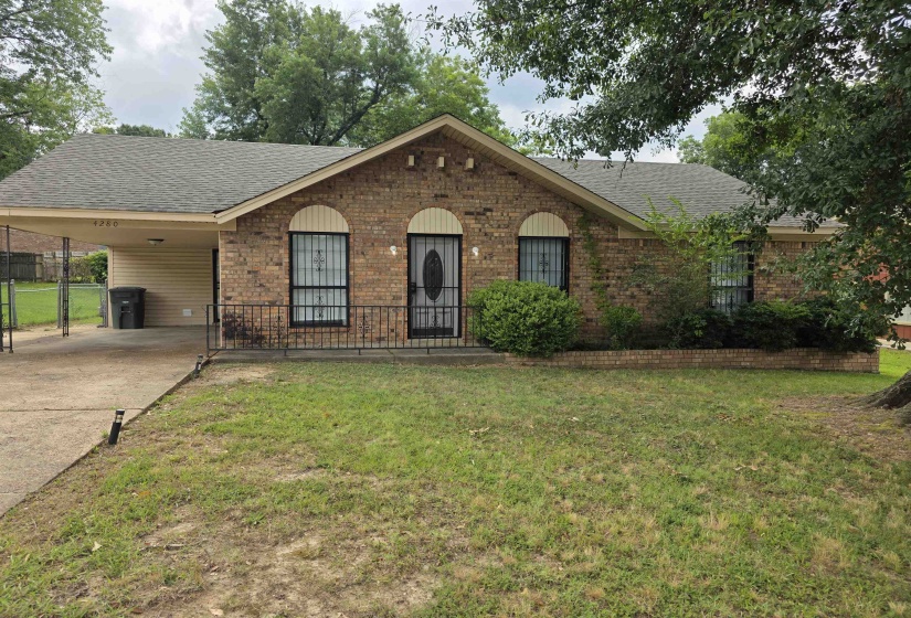 Brick exterior with a gabled roofline and a front carport