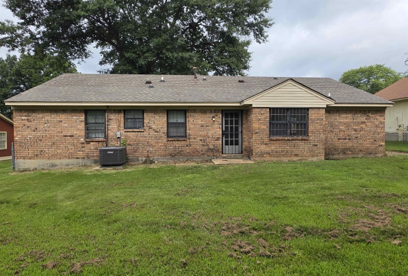 Brick exterior with a gabled roofline, multiple windows, and a rear entry door
