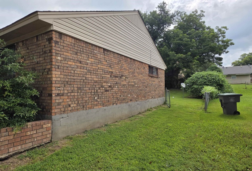 Brick exterior with a beige siding accent, featuring a green lawn and established landscaping