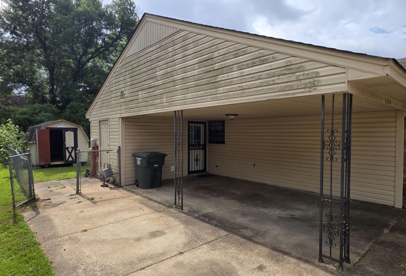 Carport with decorative metal support columns and concrete driveway