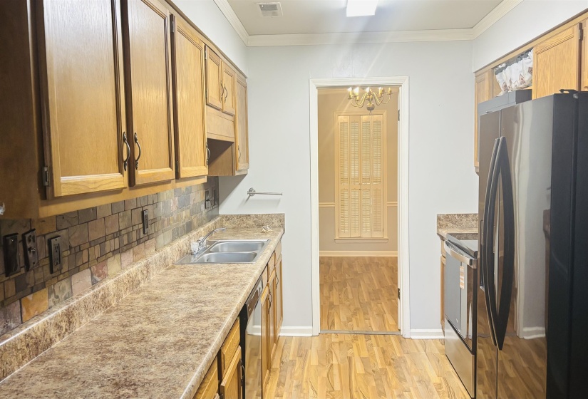 Kitchen featuring wood cabinetry, a decorative tile backsplash, and laminate countertops