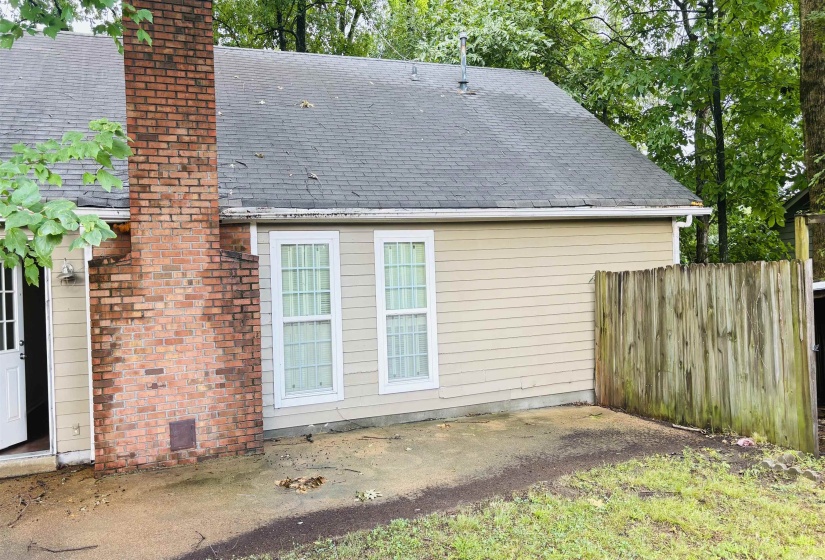 Exterior siding with two windows and a brick chimney
