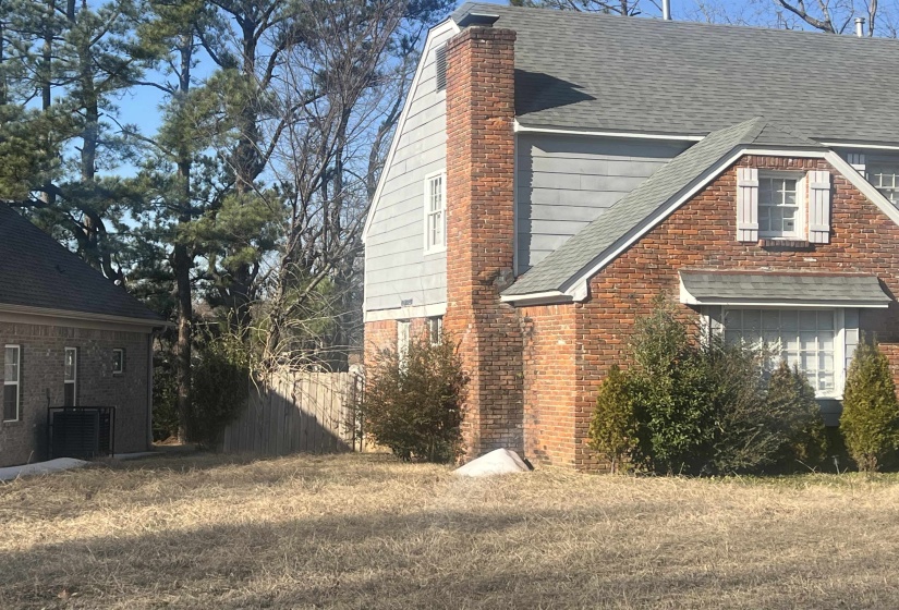 Brick exterior with gray siding accents and a pitched asphalt shingle roof