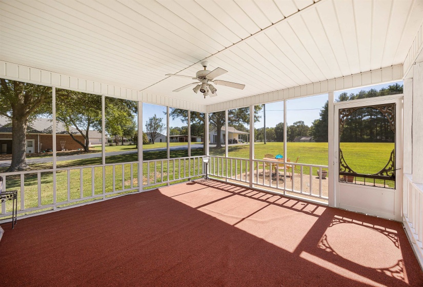 Unfurnished sunroom featuring ceiling fan and a residential view
