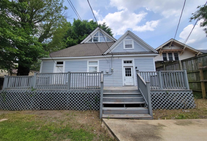Back of property featuring a deck and a shingled roof