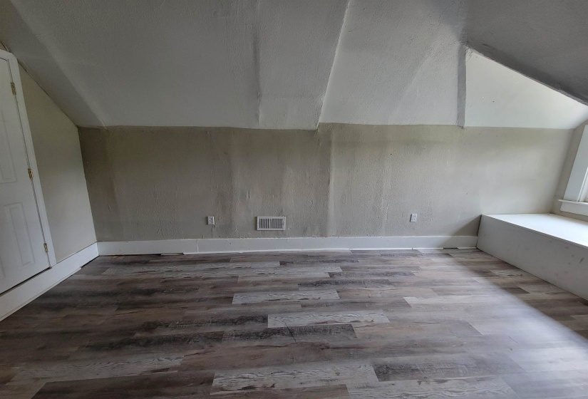 Additional living space featuring wood finished floors, lofted ceiling, and baseboards