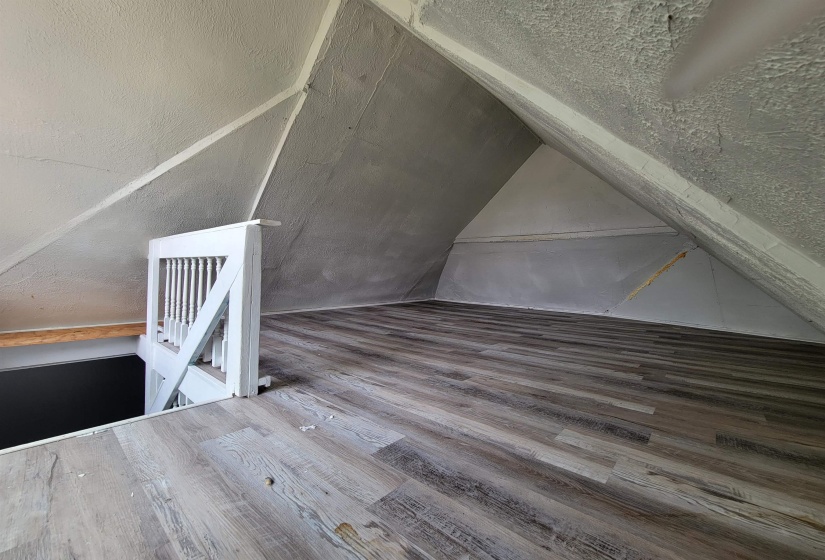 Additional living space with lofted ceiling and wood finished floors