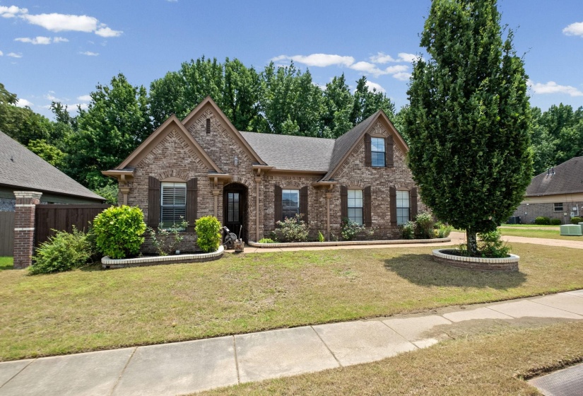 Brick exterior with gabled rooflines, dark shutters, and a covered entryway