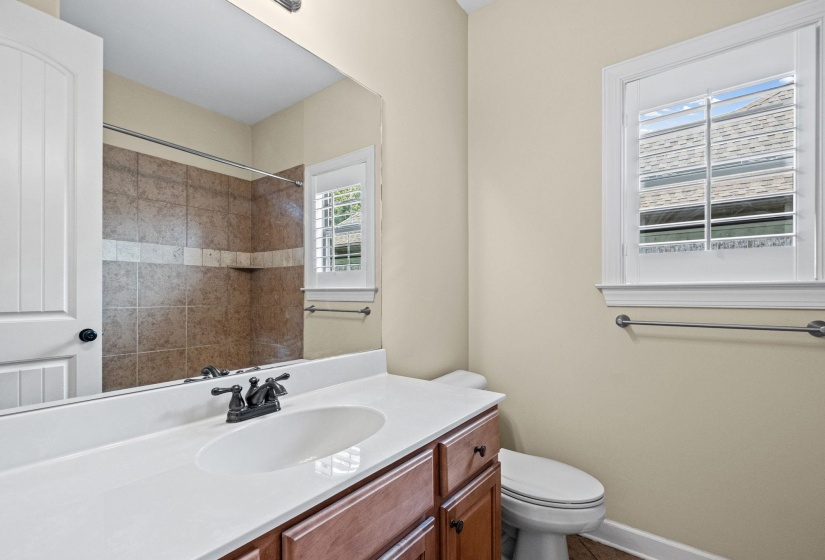 Bathroom featuring a white countertop vanity with wood-finish cabinetry and a bronze-finish faucet