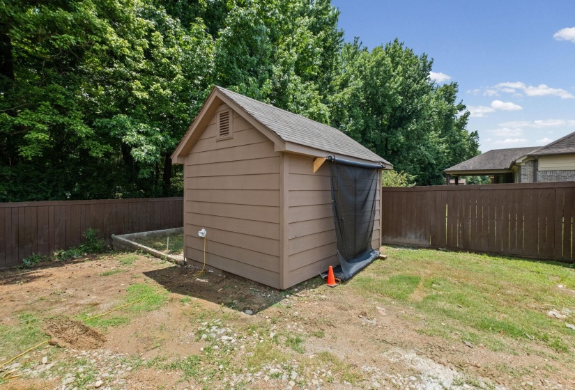 Outdoor storage shed with a shingled roof and horizontal siding