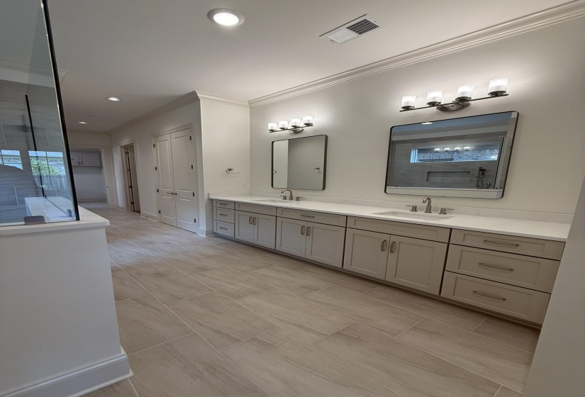 Dual vanity with light gray cabinetry, integrated sinks, and polished chrome fixtures