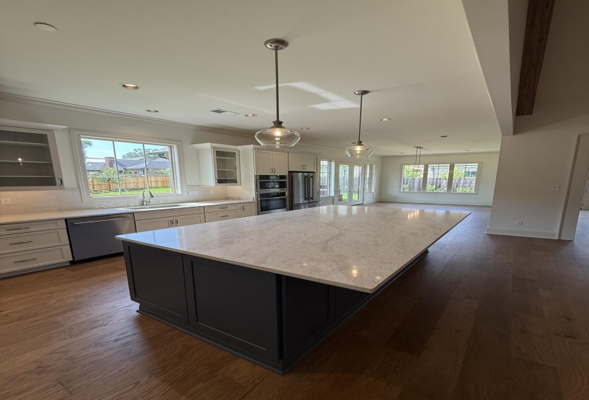 Expansive kitchen island with a light-toned countertop, complemented by pendant lighting fixtures