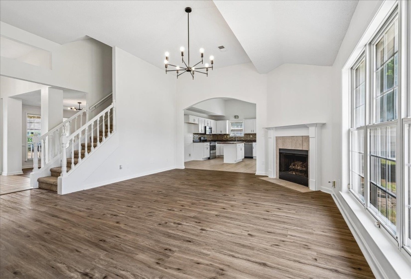 Spacious room with wood-finish flooring and a central chandelier
