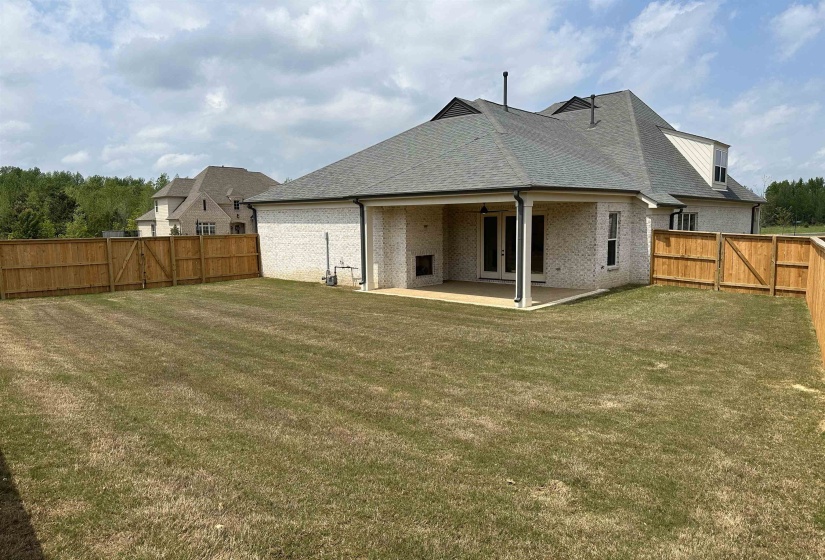 Rear view of house with a patio and a lawn