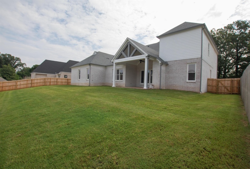 Rear view of house featuring a lawn
