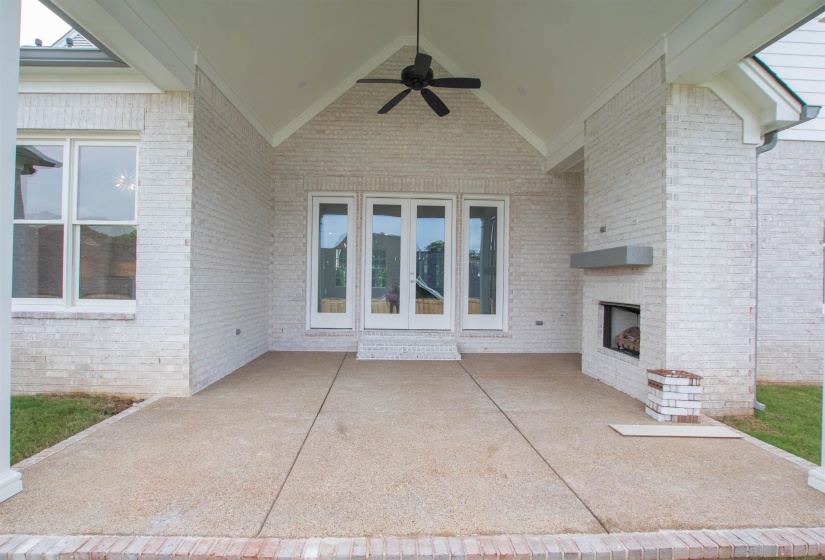 View of patio with an outdoor brick fireplace and ceiling fan