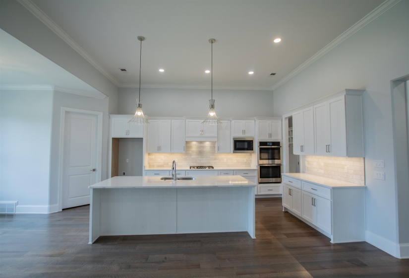 Kitchen featuring a kitchen island with sink, dark hardwood / wood-style flooring, stainless steel appliances, and backsplash