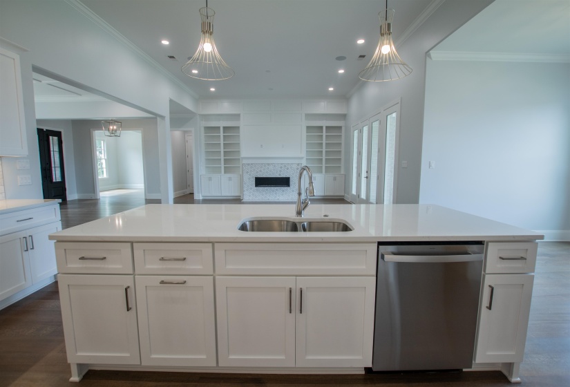 Kitchen featuring white cabinetry, stainless steel dishwasher, hardwood / wood-style floors, decorative backsplash, and sink