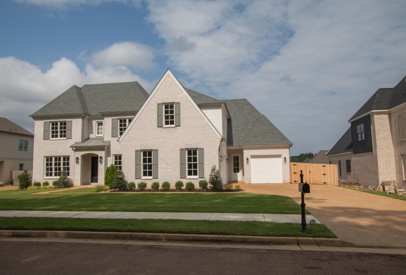View of front of property featuring a garage and a front yard