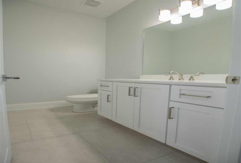 Bathroom featuring vanity, toilet, and tile patterned floors