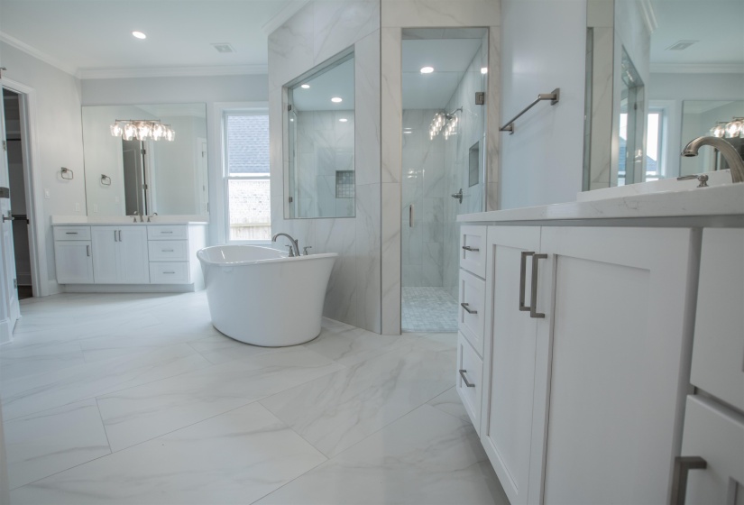 Bathroom with ornamental molding, vanity, tile patterned floors, and shower with separate bathtub