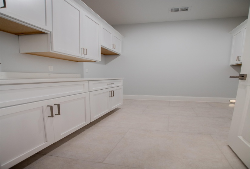 Interior space with white cabinets and light tile patterned floors
