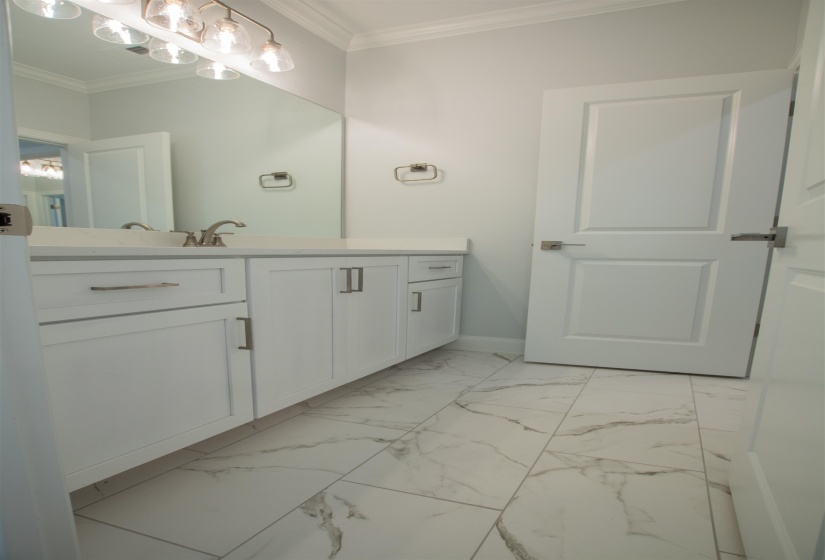 Bathroom featuring vanity, crown molding, and tile patterned flooring