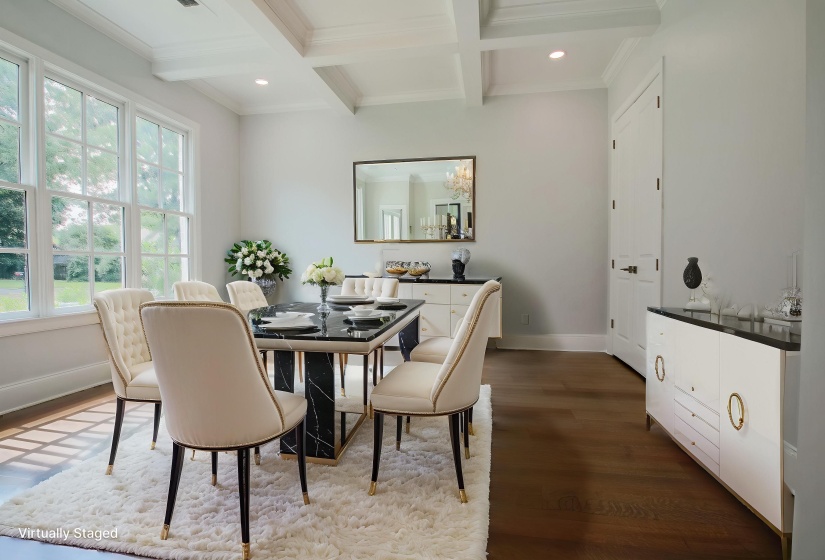 Dining space featuring beamed ceiling, wood finished floors, coffered ceiling, plenty of natural light, and ornamental molding