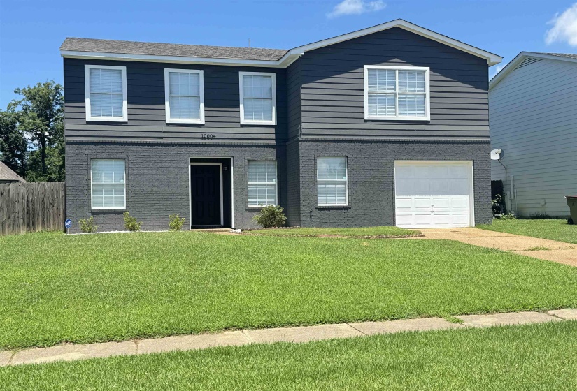 Front facade featuring a garage and a front lawn