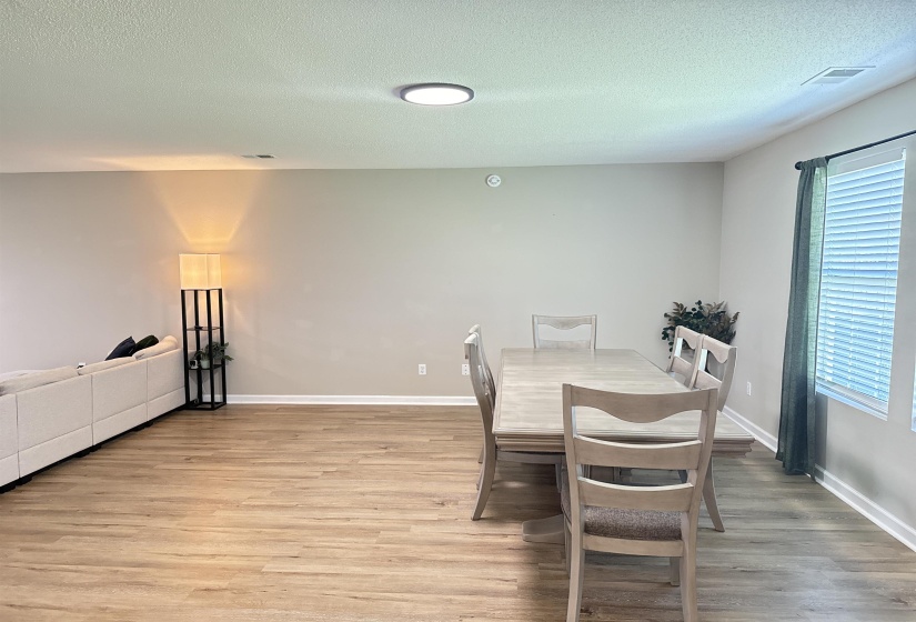 Dining space with a textured ceiling, hardwood / wood-style floors, and plenty of natural light