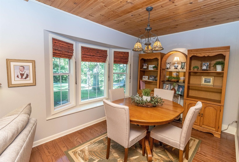 Dining area featuring wood ceiling, hardwood / wood-style floors, and ornamental molding