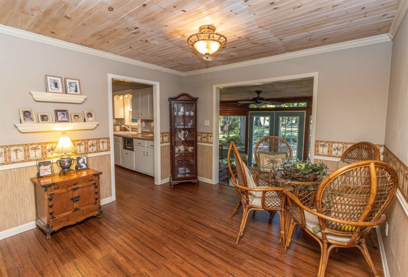 Dining area with ceiling fan, dark hardwood / wood-style flooring, ornamental molding, and wooden ceiling