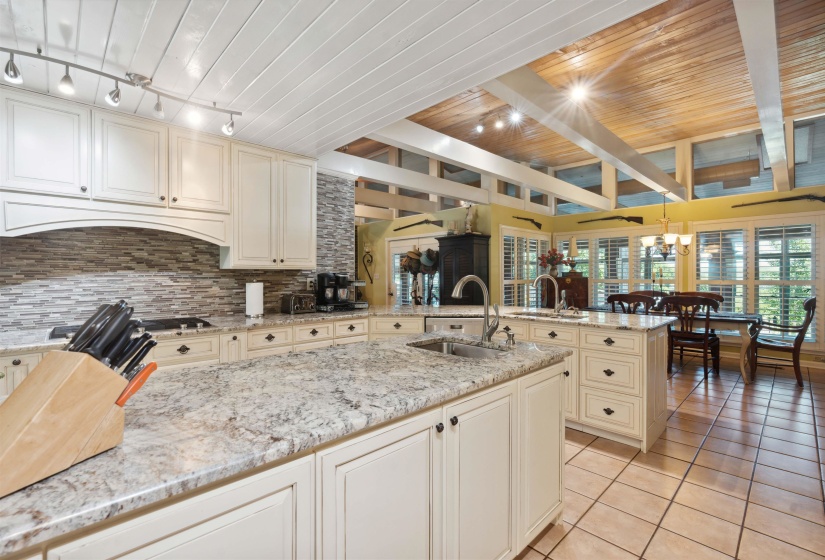 Kitchen featuring backsplash, light stone countertops, sink, and wooden ceiling