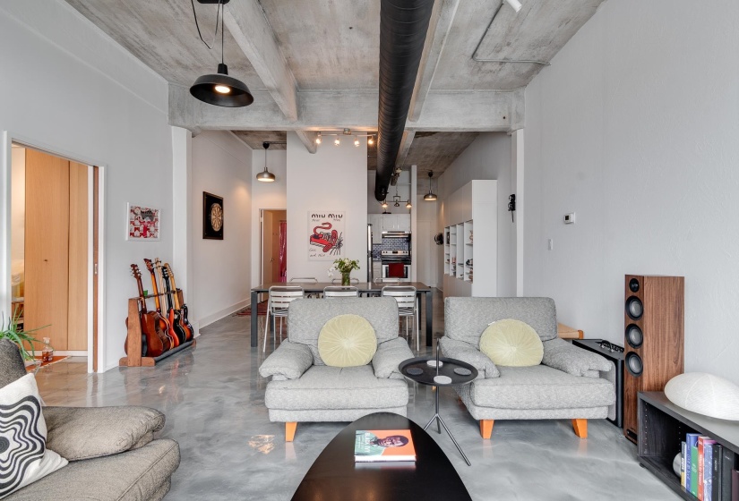 Living room with a towering ceiling and concrete floors