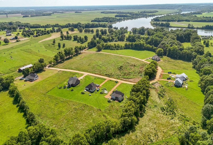 Aerial view of sparsely populated area featuring a nearby body of water and a pastoral area