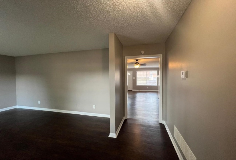 Hallway with dark wood-type flooring and a textured ceiling