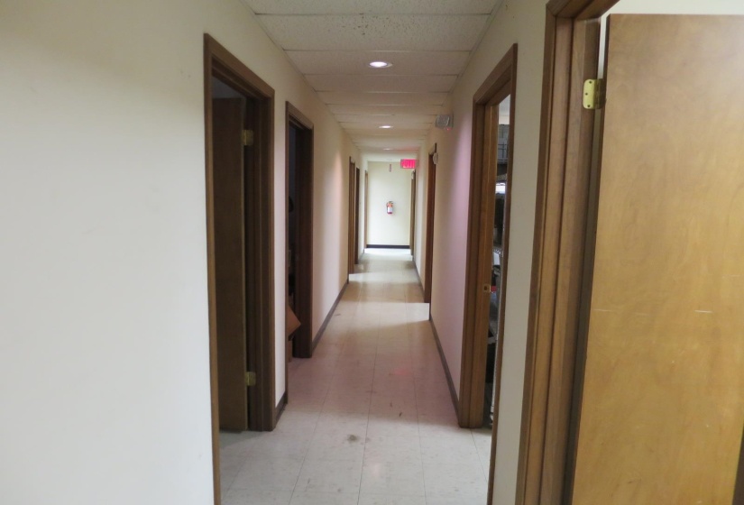 Corridor featuring tile patterned floors and a paneled ceiling
