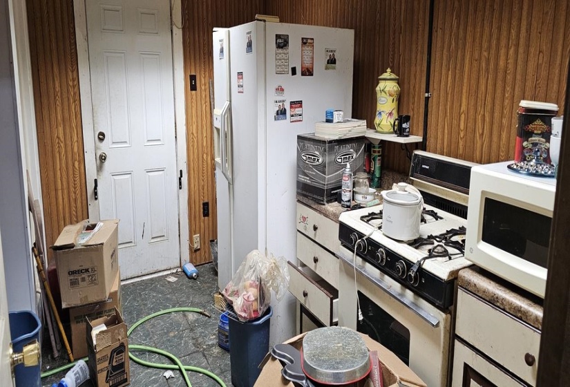 Interior space with white appliances and wooden walls