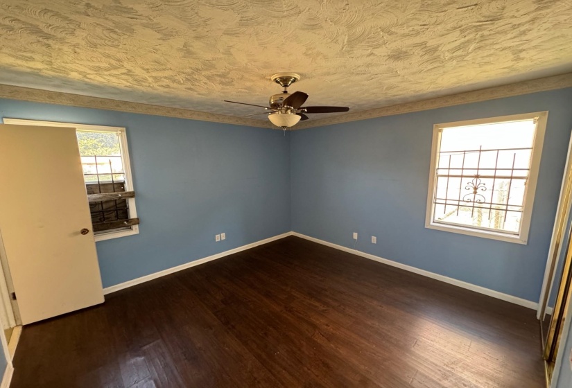 Unfurnished room featuring ceiling fan, a textured ceiling, and dark hardwood / wood-style flooring