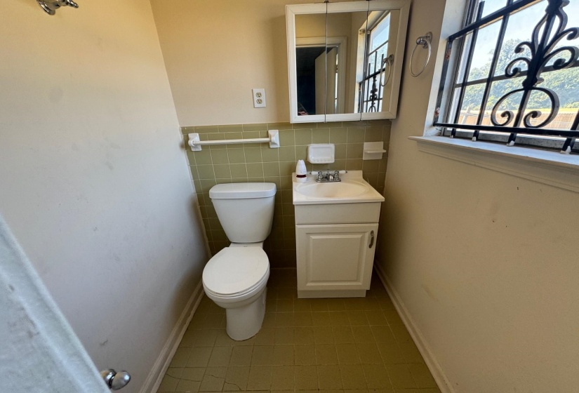 Bathroom with tile patterned flooring, tile walls, toilet, and vanity
