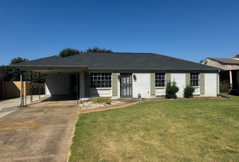 Ranch-style house featuring a front lawn and a carport