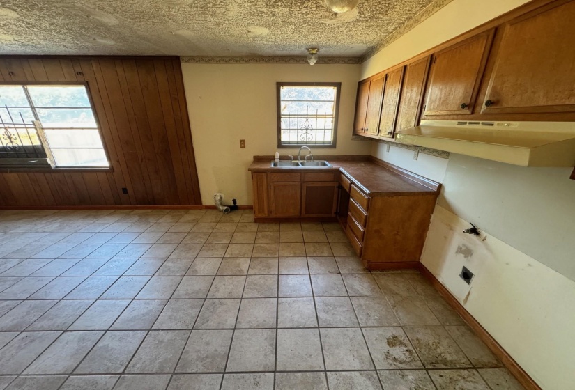 Kitchen with light tile patterned floors, sink, and a textured ceiling