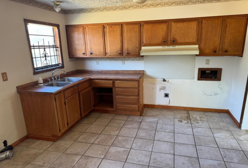 Kitchen with light tile patterned floors and sink