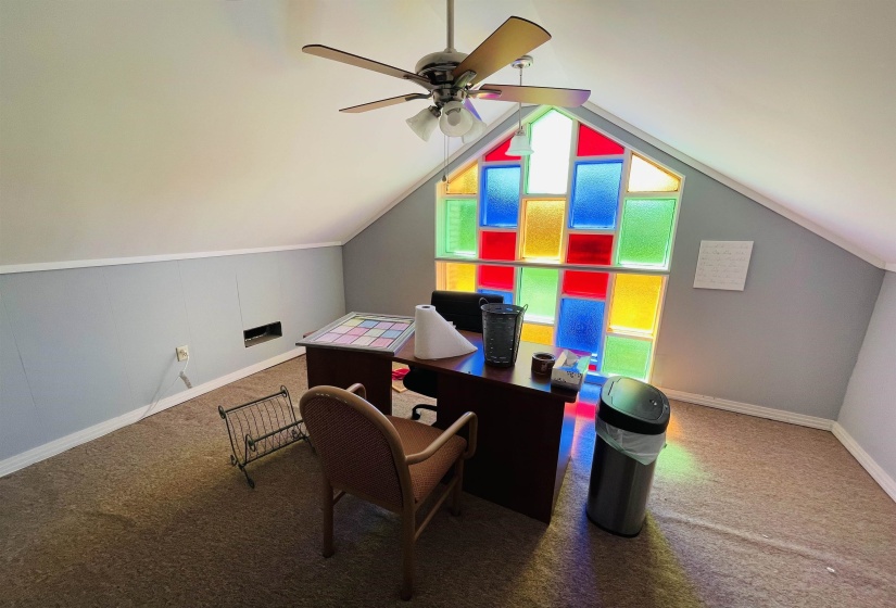 Office area with ceiling fan, carpet floors, and lofted ceiling