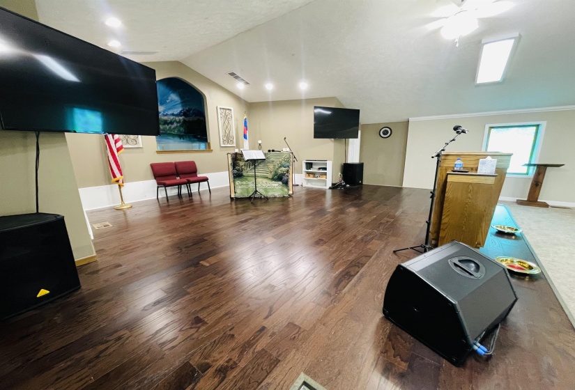 Interior space featuring wood-type flooring, vaulted ceiling, and ceiling fan