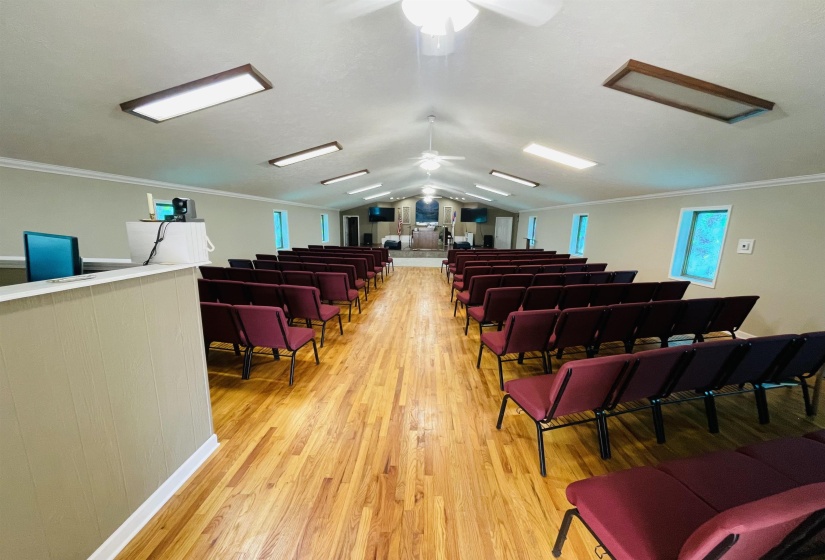 Interior space featuring crown molding, vaulted ceiling, ceiling fan, and light hardwood / wood-style flooring